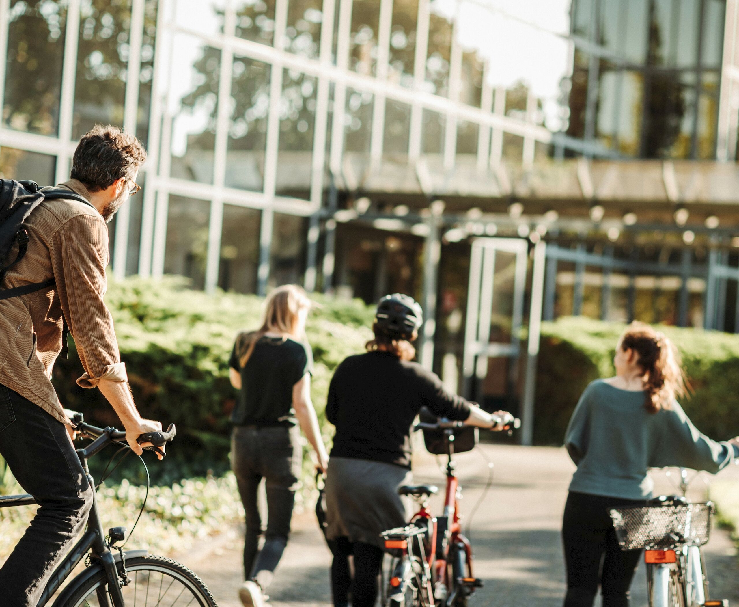 Drei Mitarbeitende sind zu Fuß und per Rad auf dem Weg ins Büro