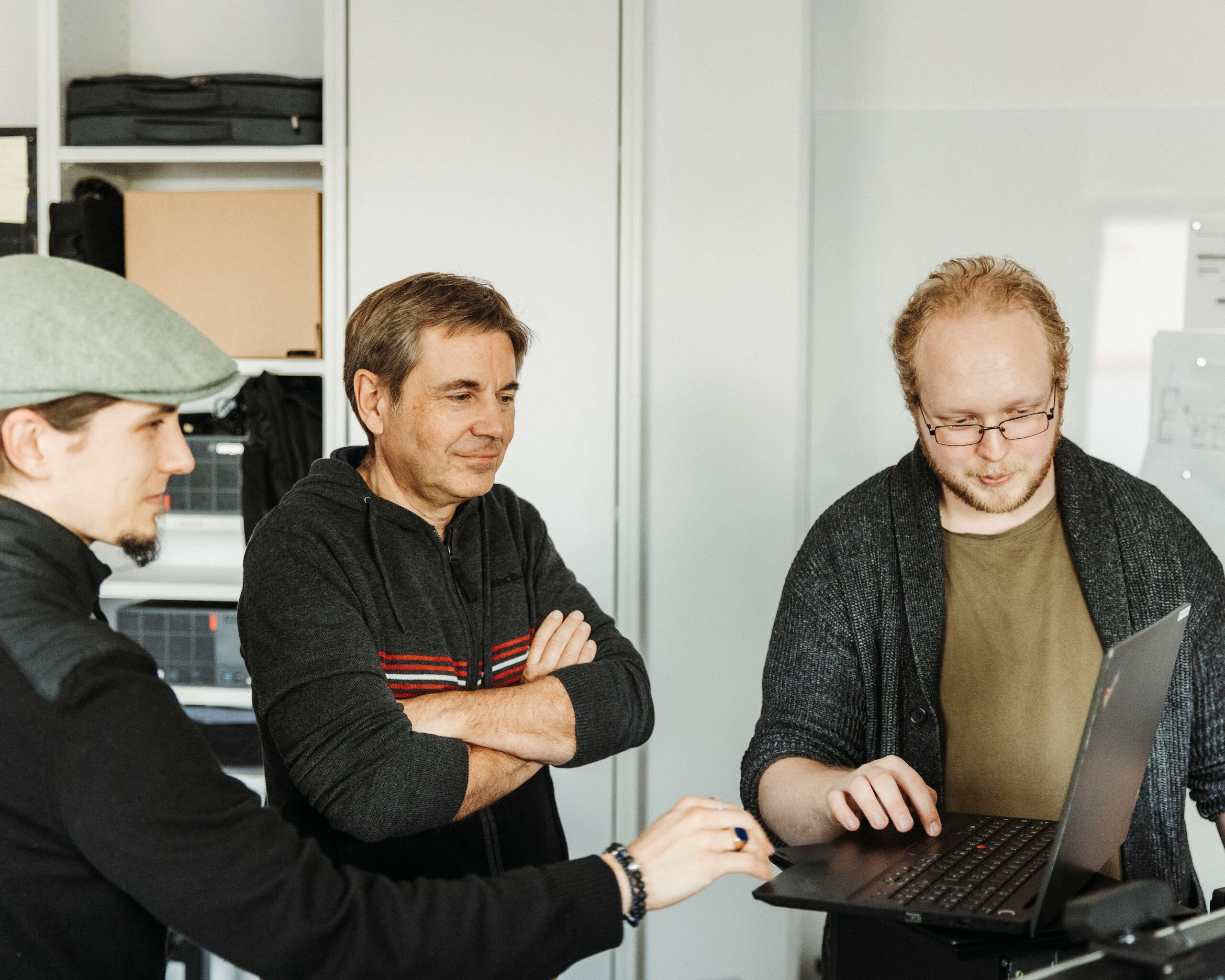 Drei Mitarbeiter sitzen vor einem Laptop
