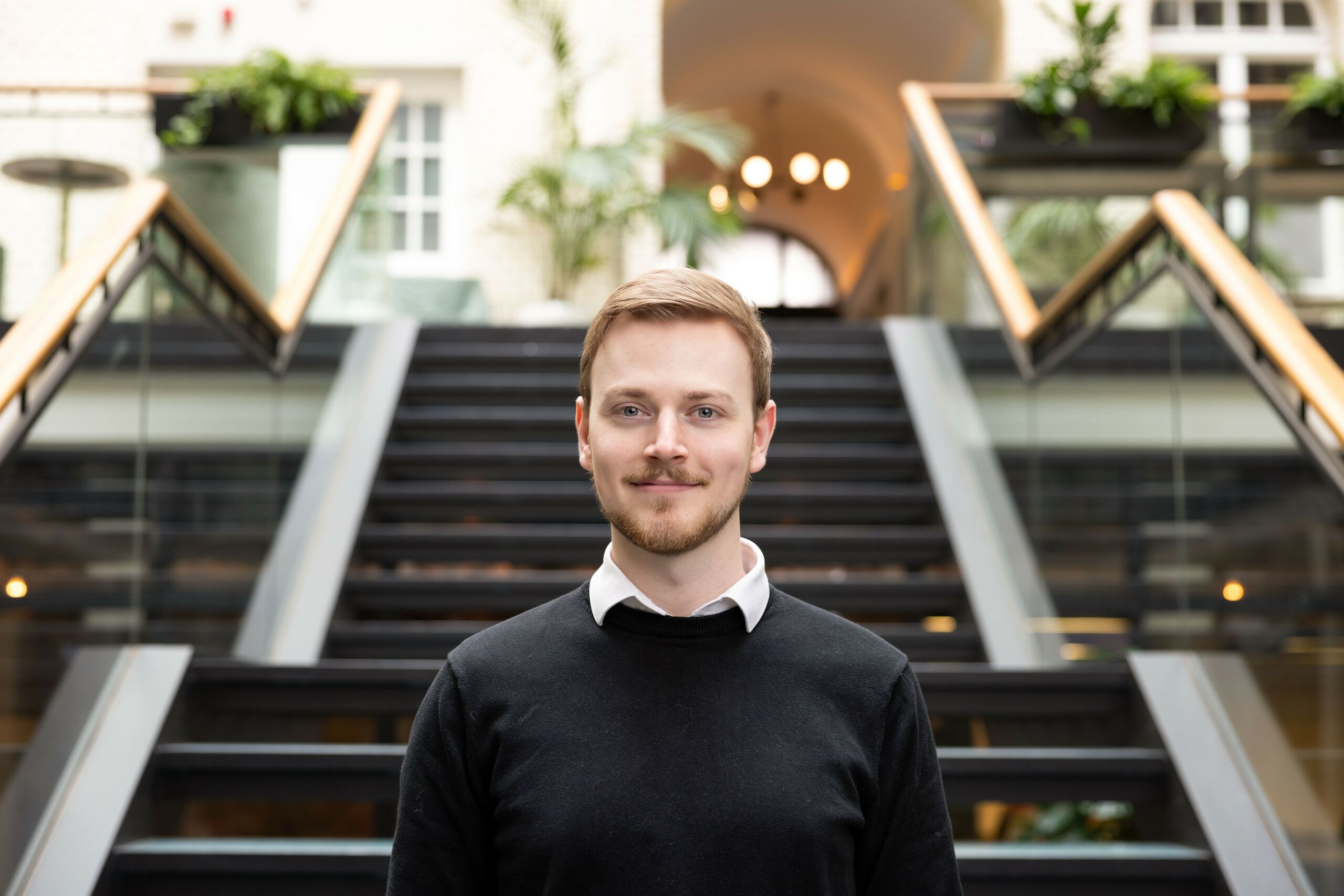 Ein junger Mann steht vor einer Treppe