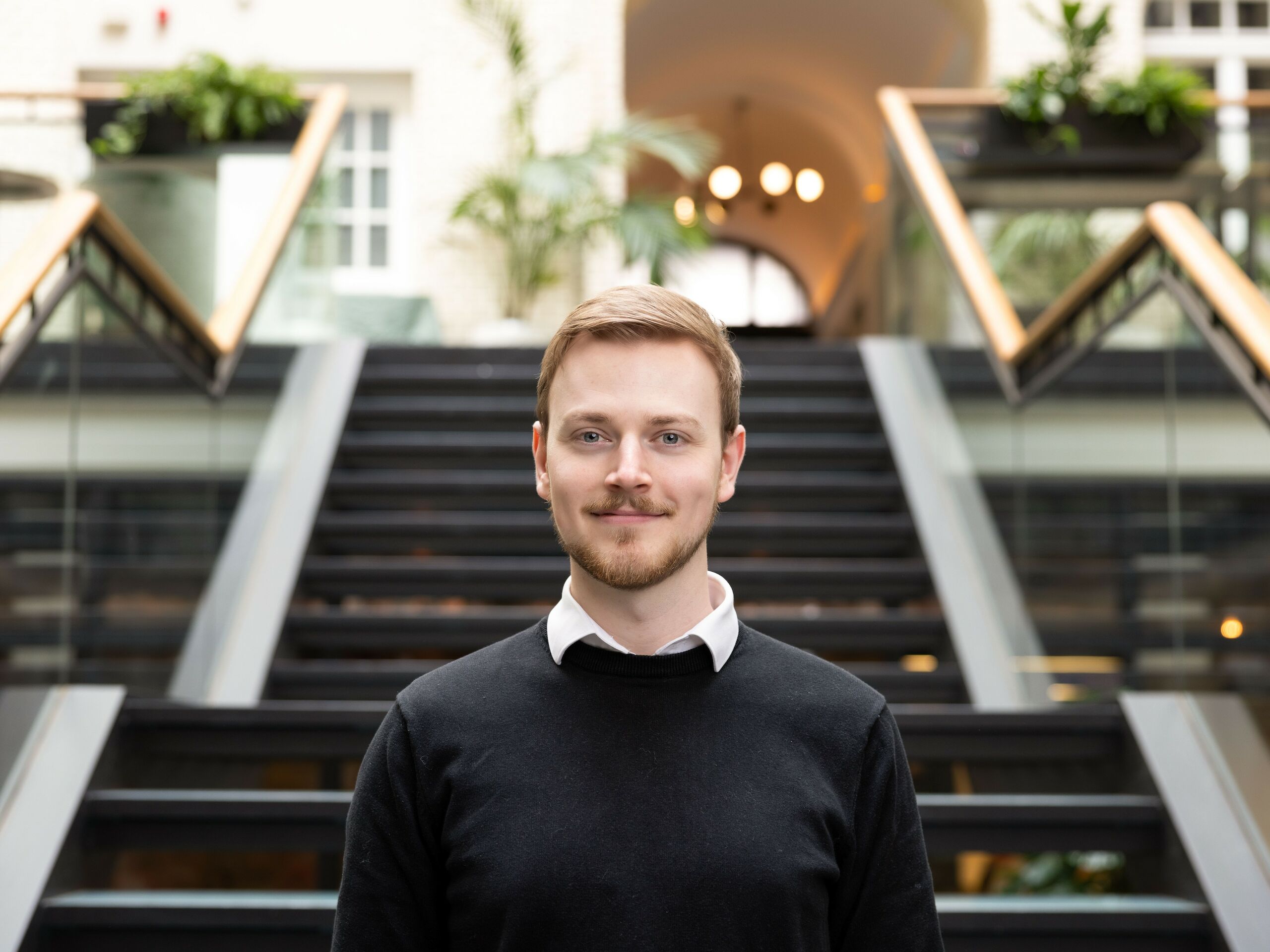 Ein junger Mann steht vor einer Treppe